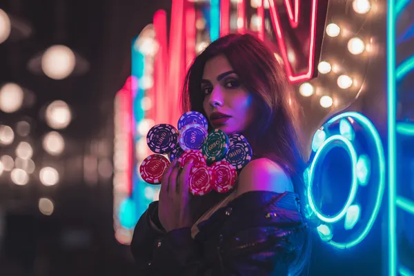 A glamorous woman holding casino chips in a neon-lit environment, representing the premium online casino atmosphere of SPINARA.